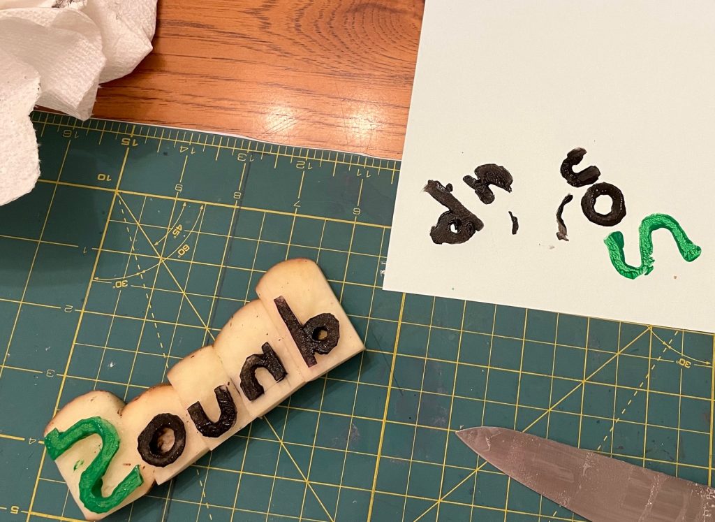 a cutting board and potato stamp pieces