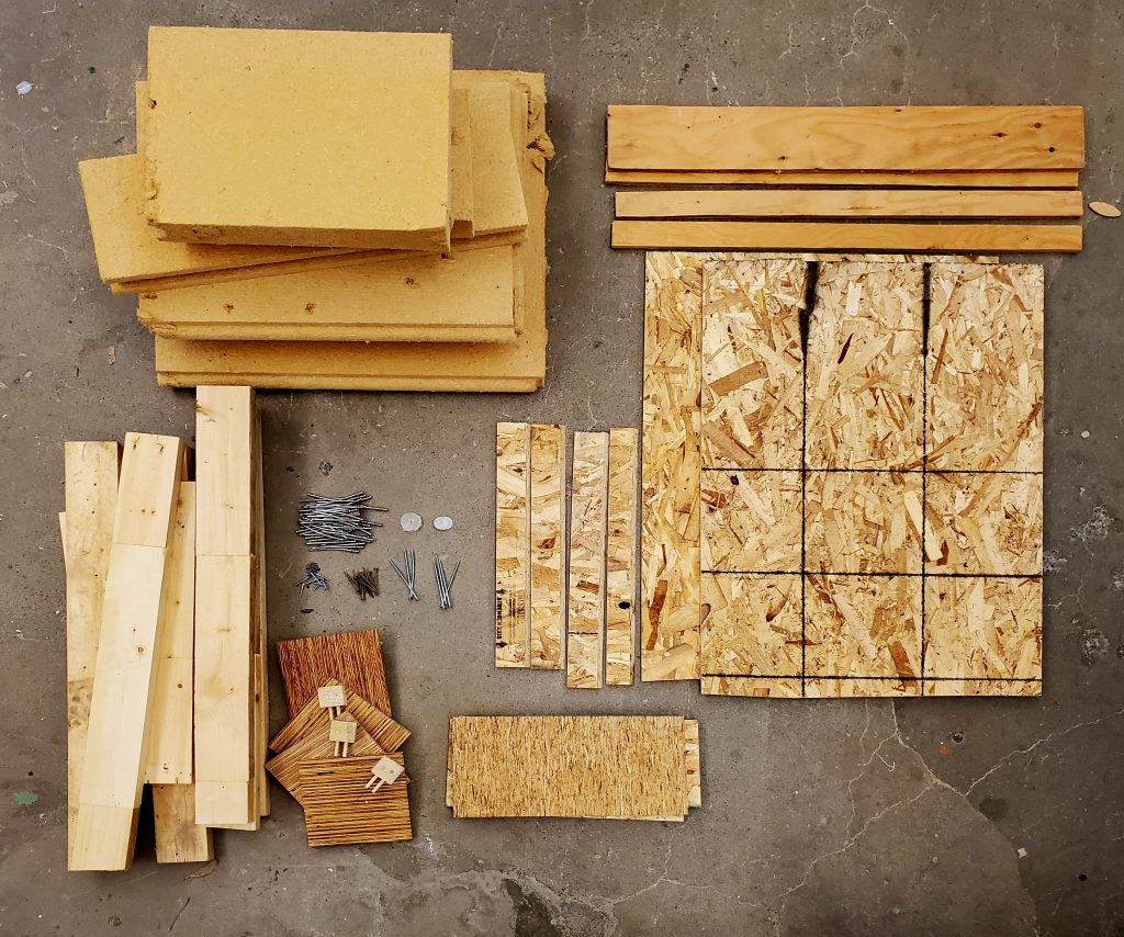 Organized piles of wood construction material from a deconstructed wall mock-up