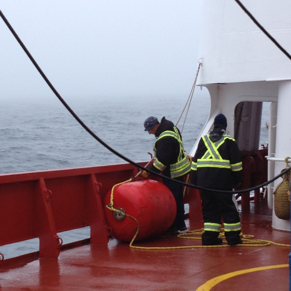 The ship’s maître d’equipage (boatswain) and crew work on the ship on a foggy Newfoundland morning. 