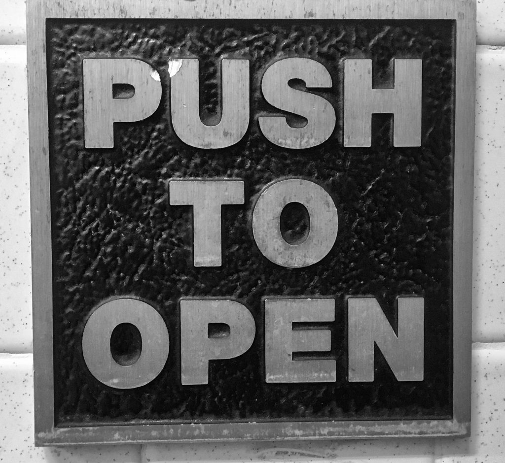 a sign on a wall with text that reads "push to open"