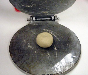 ball of masa dough in a tortilla press