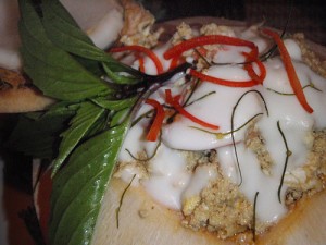 red seafood curry served in a coconut shell