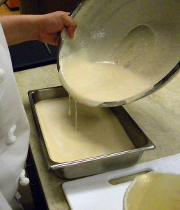 the almond ice cream mix being poured in a pan to freeze it