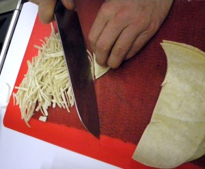 slicing tortillas into fine strips for the sopa Tarasca