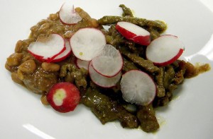 Carne en su jugo is garnished with radishes on top