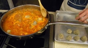 prawn albondigas (meatballs) are placed in the simmering sauce