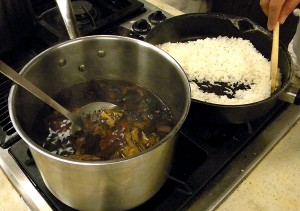 boiling the dried chiles until soft, and, in the background, frying the rice until it turns golden and sounds like 'sand in the pan'