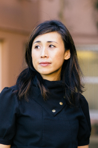 Dr. Seiki presents as an asian woman, with long dark hair. She is wearing a dark shirt in this image.