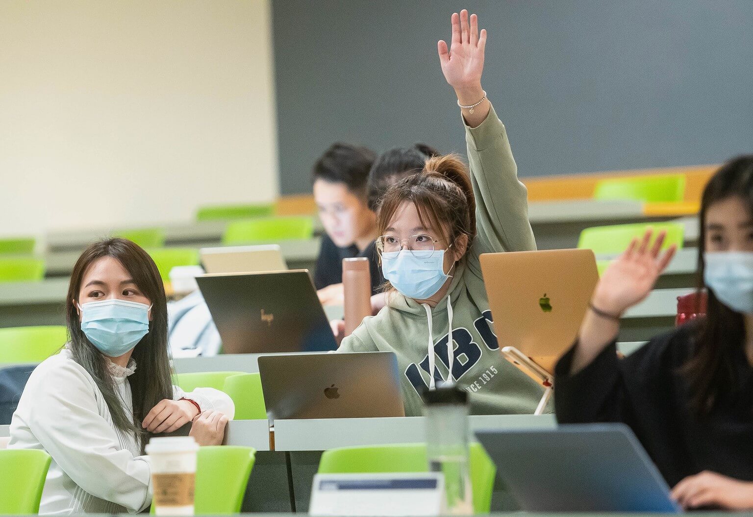 women students with hands raised