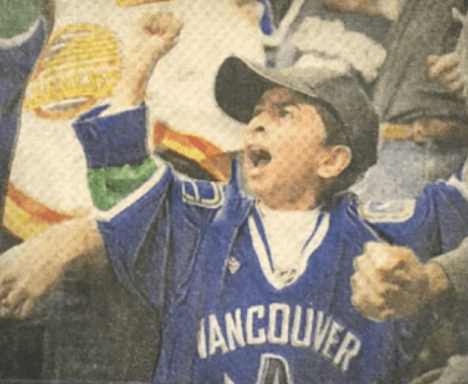 Nicholas as a child cheering at a Canucks game