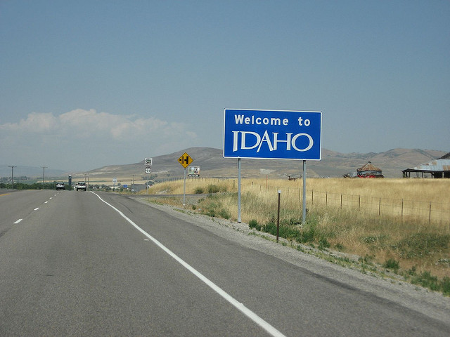Road with a sign on the side saying "Welcome to Idaho"