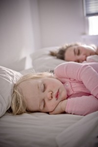 A baby and her mother asleep together