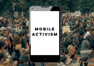 Mobile phone with the words Mobile Activism on the screen in front of a protest photo