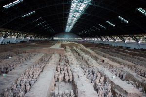 Pit one, which is 230 metres (750 ft) long and 62 metres (203 ft) wide,[30] contains the main army of more than 6,000 figures.[31] Pit one has 11 corridors, most of which are more than 3 metres (9.8 ft) wide and paved with small bricks with a wooden ceiling supported by large beams and posts. This design was also used for the tombs of nobles and would have resembled palace hallways when built. The wooden ceilings were covered with reed mats and layers of clay for waterproofing, and then mounded with more soil raising them about 2 to 3 metres (6 ft 7 in to 9 ft 10 in) above the surrounding ground level when completed. (cc) Wikipedia