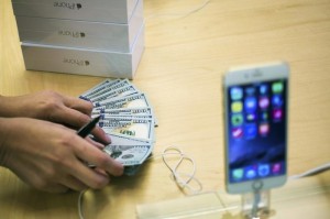 An employee counts money while selling new iPhone 6 phones at the Fifth Avenue Apple store on the first day of sales in Manhattan, New York