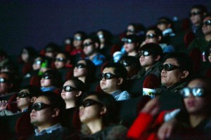 Chinese filmgoers wearing 3D glasses watch a movie at a cinema