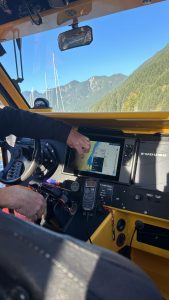 Inside the search and rescue boat observation area, the control dashboard is lit up with navigation and many controls. 