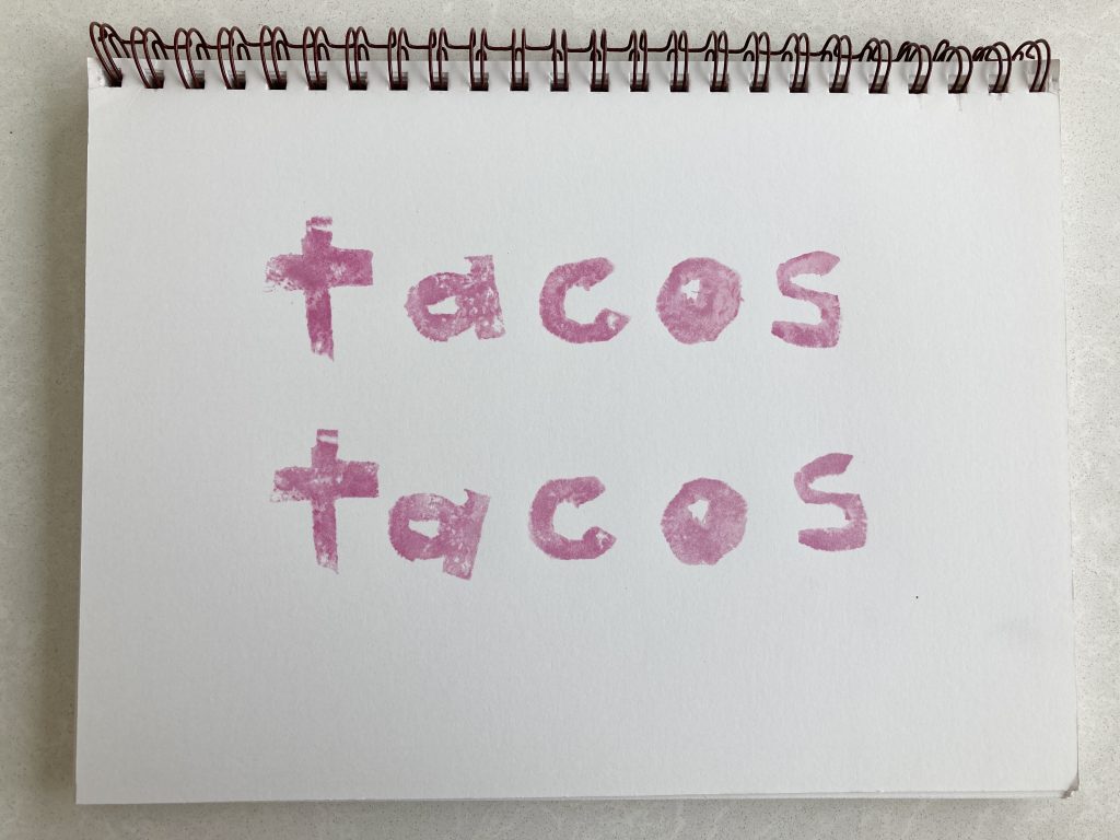 the word tacos printed twice with beet juice