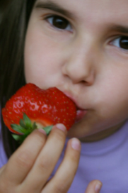 a girl eating a strawberry