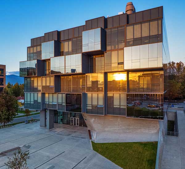 photo of west side of pharmaceutical sciences building with sunset reflecting off windows