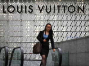 A secretary walking out of Louis Vuitton after purchasing a bag. Photo: business insider