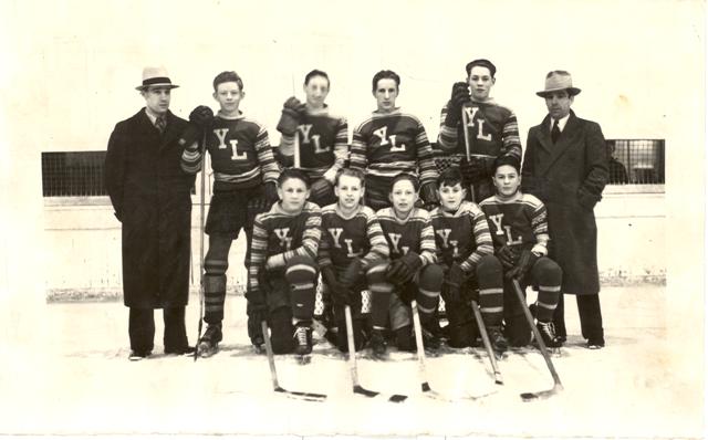 Photograph of hockey team in uniform with sticks