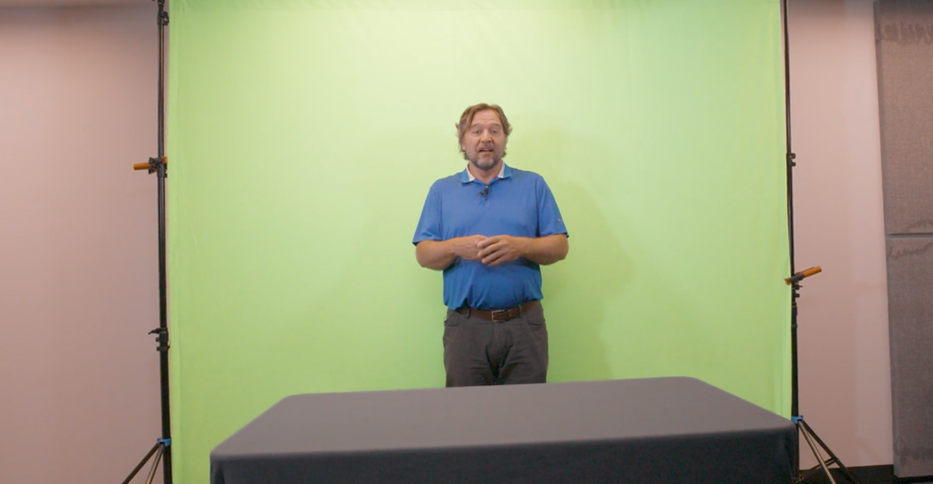 A picture showing a professor in front of an unedited greenscreen.