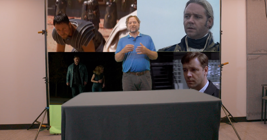 A picture showing a professor in front of an edited greenscreen showing four stills from various movies.